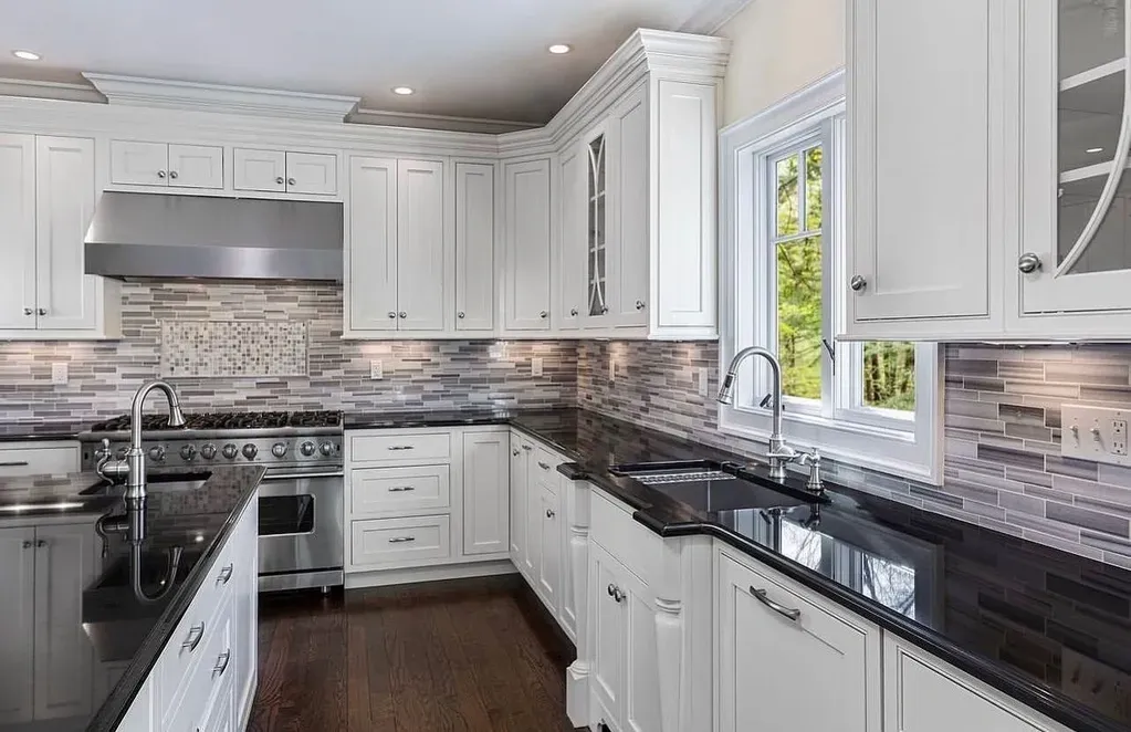 Traditional kitchen remodel in Hillsboro OR with solid-wood white raised-panel cabinetry, black granite countertops, pro-style stainless range, and mixed-stone mosaic backsplash